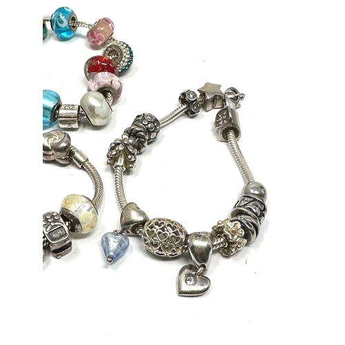 301 - Three silver mixed brand charm bracelets and charms (124g)