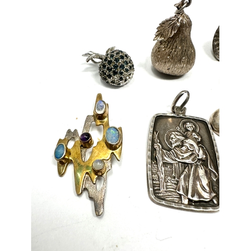 337 - A collection of silver pendants including an apple and pear (56g)