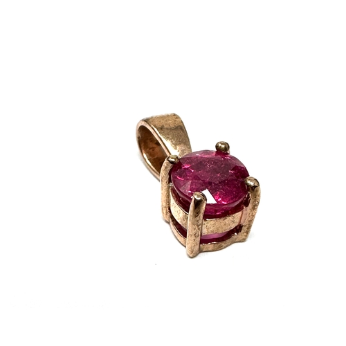 123 - 9ct gold ruby pendant measures approx 1.4cm drop by .5 cm wide weight1.1g