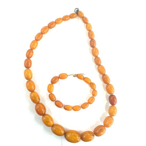 545A - Antique egg yolk amber bead necklace and bracelet with internal streaking total weight 82grams large... 