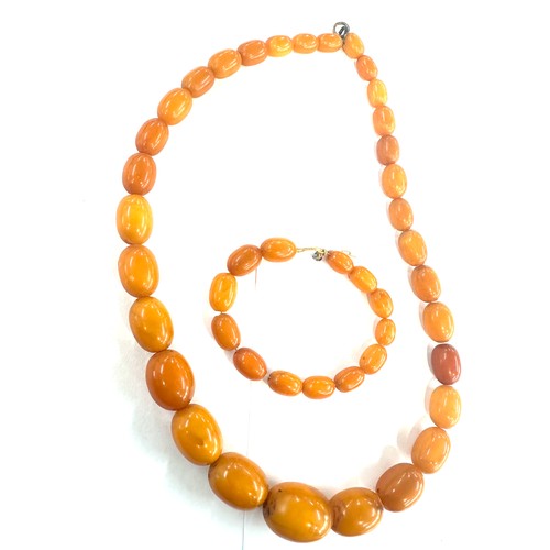 545A - Antique egg yolk amber bead necklace and bracelet with internal streaking total weight 82grams large... 