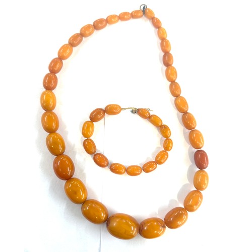 545A - Antique egg yolk amber bead necklace and bracelet with internal streaking total weight 82grams large... 