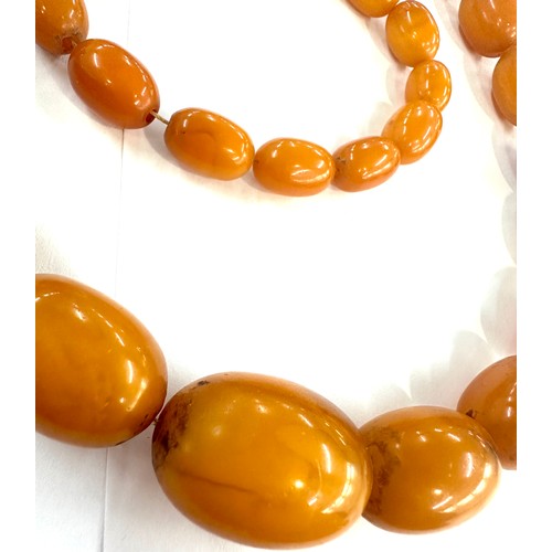 545A - Antique egg yolk amber bead necklace and bracelet with internal streaking total weight 82grams large... 