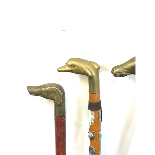 110 - Selection of vintage wooden walking sticks with brass handles includes horse, dog, dolphin etc