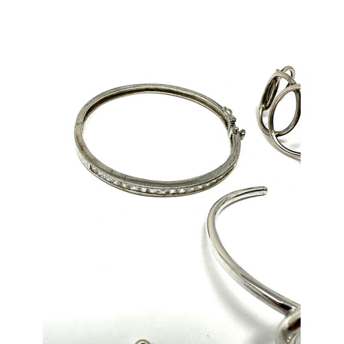 349 - Four silver bangles & bracelet including CZ (74g)