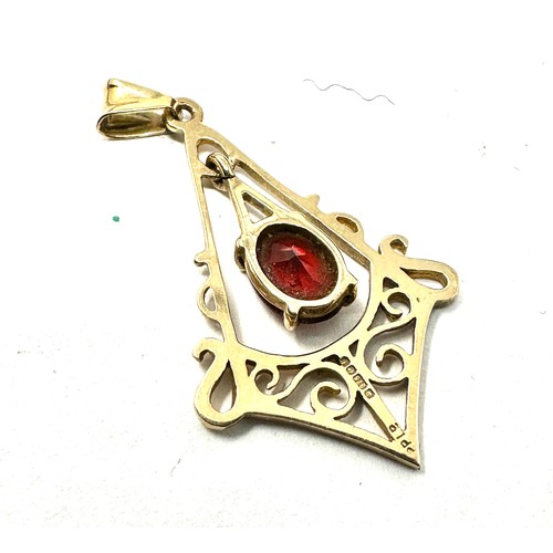 251 - 9ct gold garnet scroll pierced patterned pendant (1.3g)