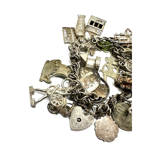 299 - A vintage silver charm bracelet with assorted novelty charms (77g)