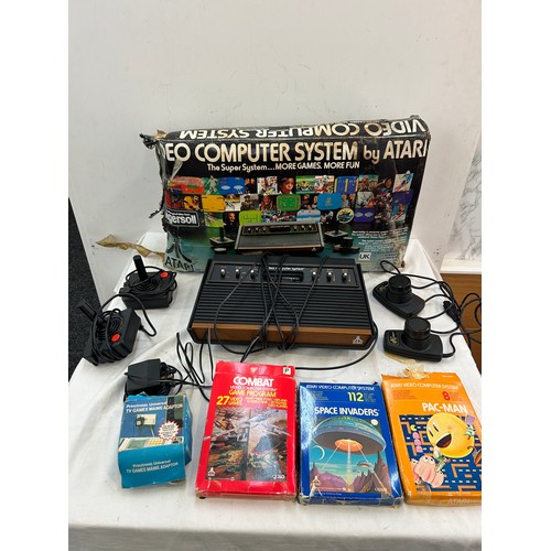 147 - Vintage Atari CX-2600 with combat game program,  pacman and space invaders, joystick and paddles, al... 