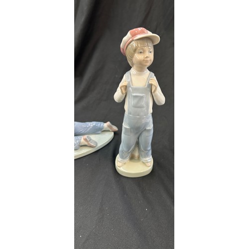 596 - Lladro boy with train, Lladro boy with harmonica both in good overall condition