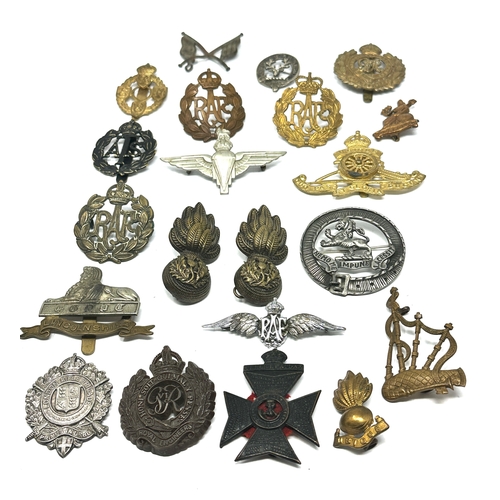 335 - 21 military cap badges and badges