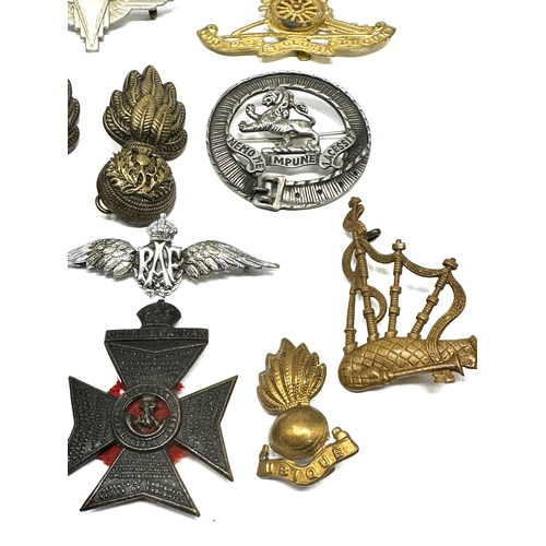 335 - 21 military cap badges and badges