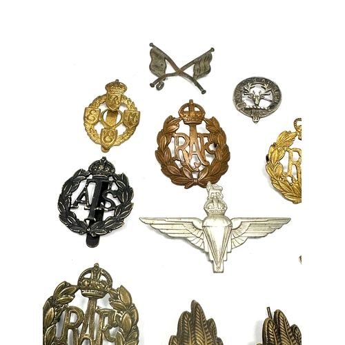 335 - 21 military cap badges and badges