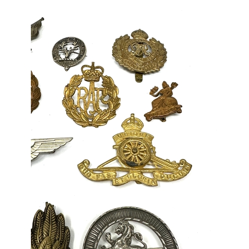 335 - 21 military cap badges and badges