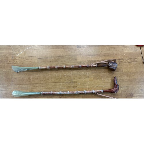 105 - 2 Carved cane shoe horns