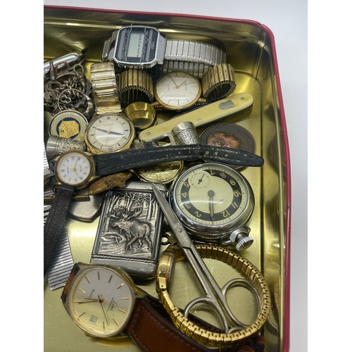 557 - Tin of collectables to include victorian fine silver pocket watch, vesta case, wrist watches, pen kn... 