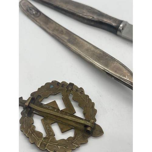 525 - WW2 German SS knife and fork together with an original SA-Sportabzeichen badge in bronze