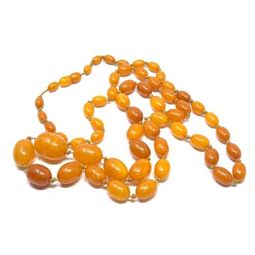 69 - Vintage long egg yolk amber bead necklace measures approx  115 cm long weight approx 52g