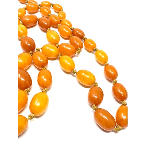 69 - Vintage long egg yolk amber bead necklace measures approx  115 cm long weight approx 52g