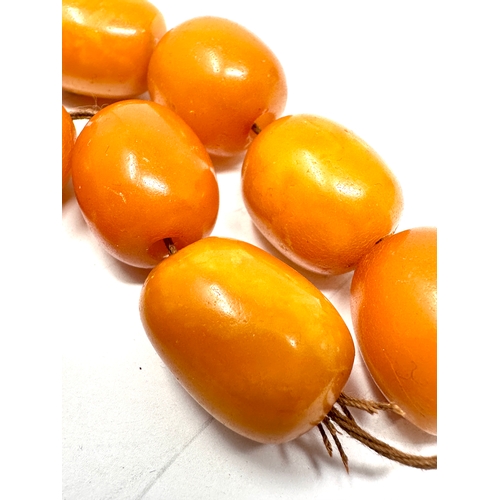 72 - Egg yolk amber beads average size of beads approx 21mm by 16mm weight 50g