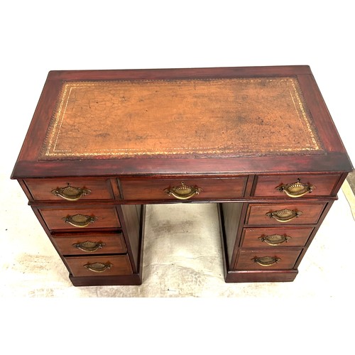 292 - Antique mahogany leather top 9 drawer desk measures approx 27 inches tall by 37.7 inches wide