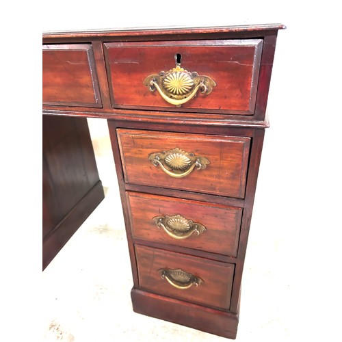 292 - Antique mahogany leather top 9 drawer desk measures approx 27 inches tall by 37.7 inches wide