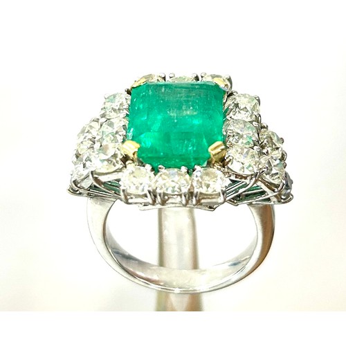 Stunning ladies natural Beryl rectangular Emerald and diamond ring in a platinum setting. The emerald measures approximate 13.29 x 10.94 x 8.99mm, with an estimated carat of 9.59, the colouring is strong green, clarity: moderately included. Origin Colombia. The emerald is surrounded by 18 natural diamonds. Overall gross weight of ring is 12.83g.  The ring is accompanied by a Gem Lab report dated 25th January 2024, stating the emerald as natural beryl, with evidence of moderate fracture filling, origin opinion Colombia. Ring size: S