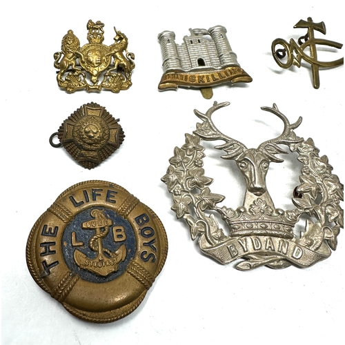 565 - selection of military cap badges etc