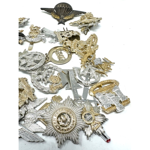 567 - large selection of military cap badges etc