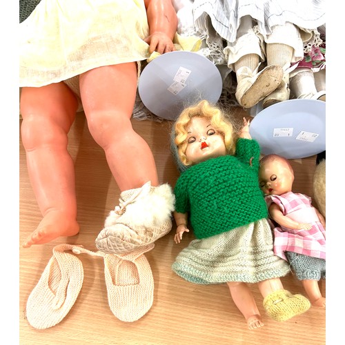 244 - Selection of vintage dolls various sizes to include a vintage wooden dolls cot, additional clothing