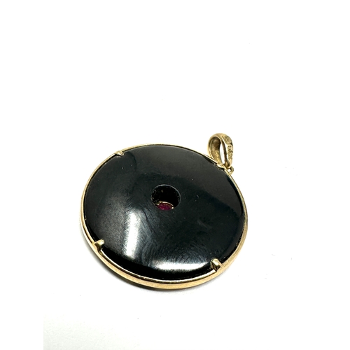 78 - 9ct gold ruby 7 black stone pendant measures approx 2.6cm dia weight 6.9g