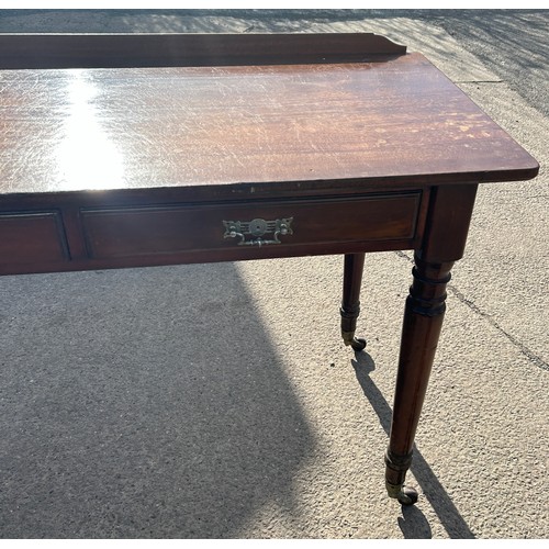 334 - 2 drawer mahogany side table, turned legs, brass castors, approximate measurements: Height 31 inches... 