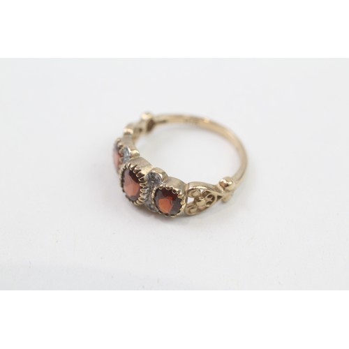 275 - 9ct gold garnet three stone ring with diamond dividers (2.3g) ring size L/M