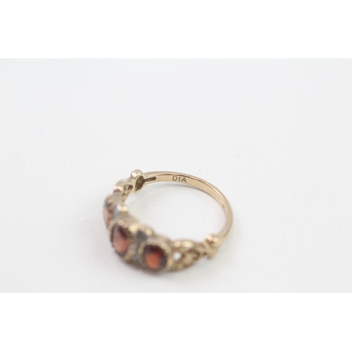 275 - 9ct gold garnet three stone ring with diamond dividers (2.3g) ring size L/M