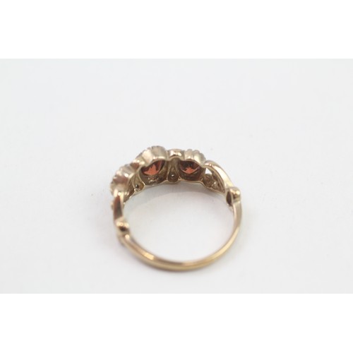 275 - 9ct gold garnet three stone ring with diamond dividers (2.3g) ring size L/M