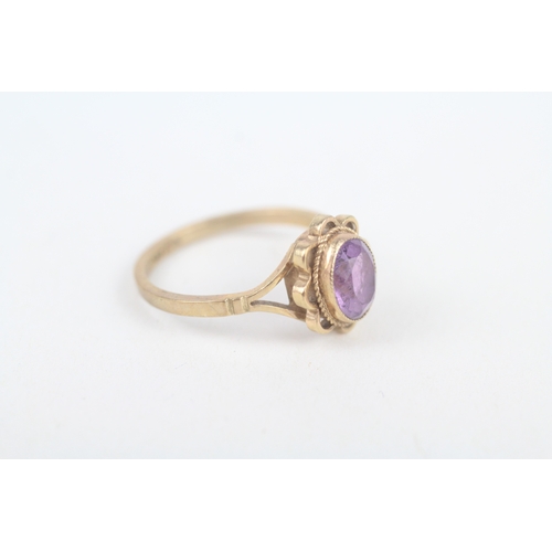 217 - 9ct gold oval cut amethyst single stone ring with wavy openwork frame