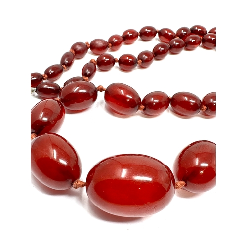 129 - Antique cherry amber / bakelite bead necklace with internal streaking weight 60g 9ct gold clasp