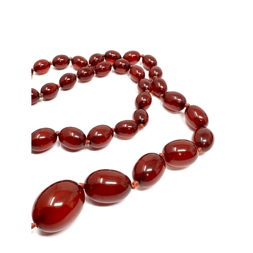 129 - Antique cherry amber / bakelite bead necklace with internal streaking weight 60g 9ct gold clasp