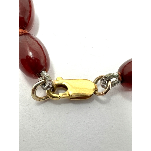 129 - Antique cherry amber / bakelite bead necklace with internal streaking weight 60g 9ct gold clasp