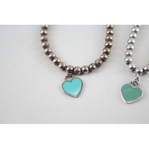 305 - Two silver bracelets with enamel heart charms by designer Tiffany & Co (11g)