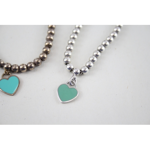 305 - Two silver bracelets with enamel heart charms by designer Tiffany & Co (11g)