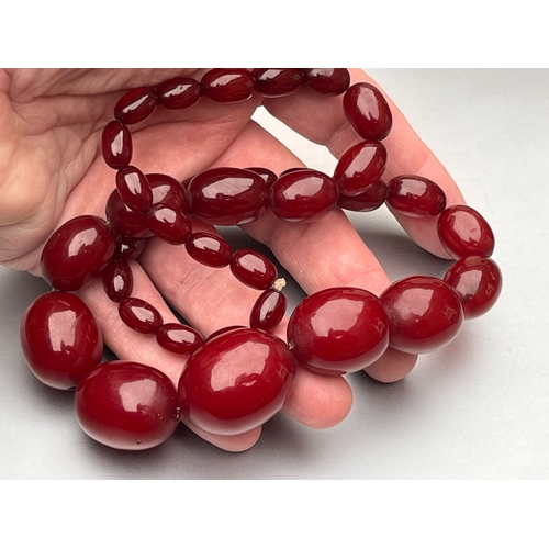 191 - Antique art deco cherry red amber / bakelite bead necklace good internal streaking weight 84g larges... 