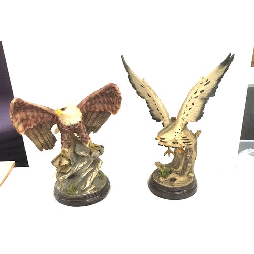 251 - Two eagle figures on stands largest measures approx 22 inches tall by 16 inches wide