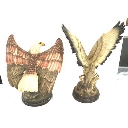 251 - Two eagle figures on stands largest measures approx 22 inches tall by 16 inches wide