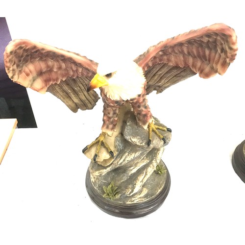 251 - Two eagle figures on stands largest measures approx 22 inches tall by 16 inches wide