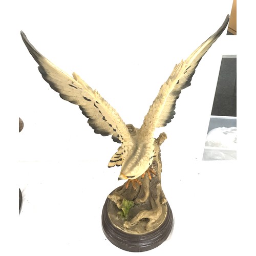 251 - Two eagle figures on stands largest measures approx 22 inches tall by 16 inches wide
