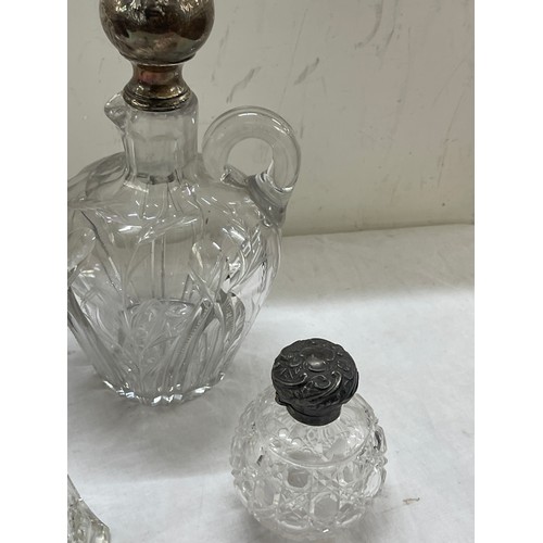 565 - Sterling silver mounted claret jug plus other silver topped bottles