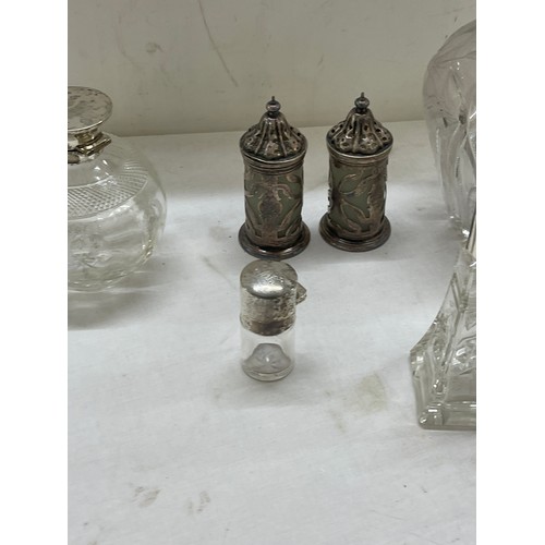 565 - Sterling silver mounted claret jug plus other silver topped bottles