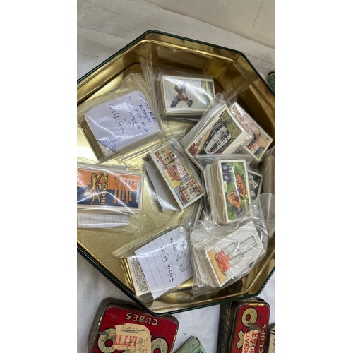 209 - Selection of cigarette card loose as well as an album of cards together with some vintage empty tins