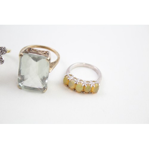 310 - Four silver stone set cocktail rings including diamond and opal (33g)