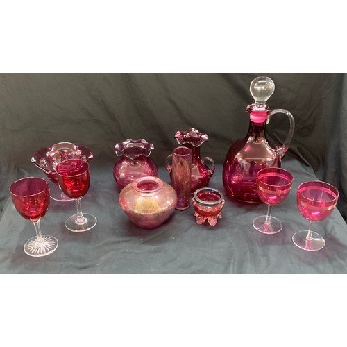 24 - Selection of cranberry glass ware to include a decanter, jugs, trifle dishes etc